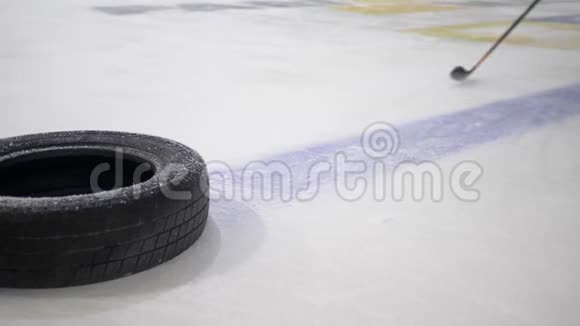 运动员在溜冰场上用曲棍球棒打冰球冰球比赛用汽车轮胎视频的预览图