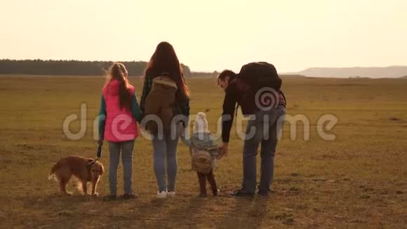 爸爸妈妈女儿和宠物游客亲密家庭的团队合作一家人带着狗穿过视频的预览图