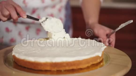 厨师手的特写镜头他把香草奶油放在蛋糕上视频的预览图