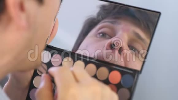 年轻人用镊子在家里的镜子前拔掉眉毛视频的预览图