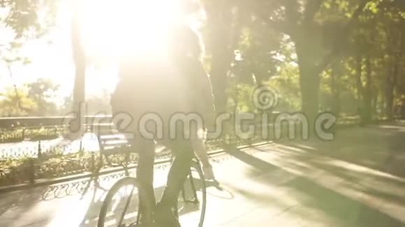 有爱心的年轻夫妇在户外活动中骑在同一辆自行车上玩得很开心背景是阳光背光女孩是视频的预览图