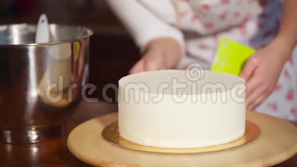 厨师用锅铲装饰蛋糕的手的特写镜头视频的预览图