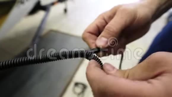 镜头显示人的手使用将黑色电线放入长螺旋电缆视频的预览图