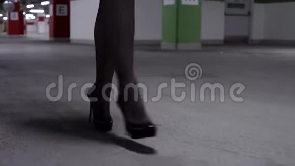 步行妇女黑色长袜和高跟鞋在停车场的看法视频的预览图