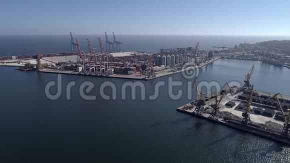 用集装箱和起重机在蓝天和闪亮的海上堤岸上飞越工业贸易港口视频的预览图