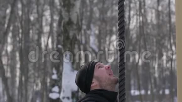 运动员在冬季运动场上爬绳运动员男子户外训练视频的预览图
