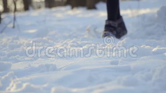 冬天穿靴子的女人在雪地上慢动作视频的预览图