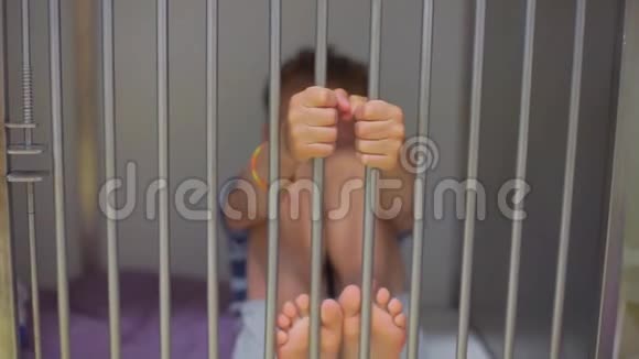 铁笼子里的孩子用手握着铁棍视频的预览图