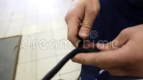 相机显示男性的手使用放置黑线到长螺旋电缆视频的预览图