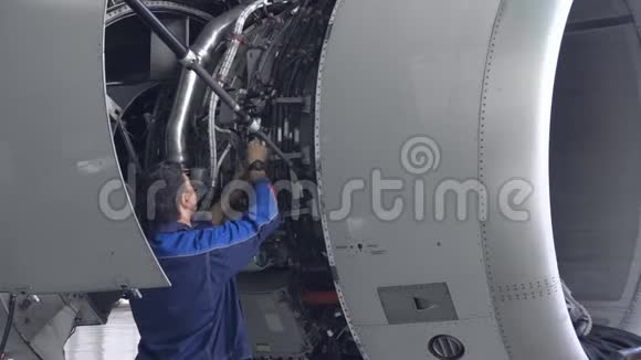 工程师技术人员用手电筒检查喷气发动机视频的预览图