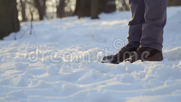 穿着靴子的男人慢慢地踢雪视频的预览图