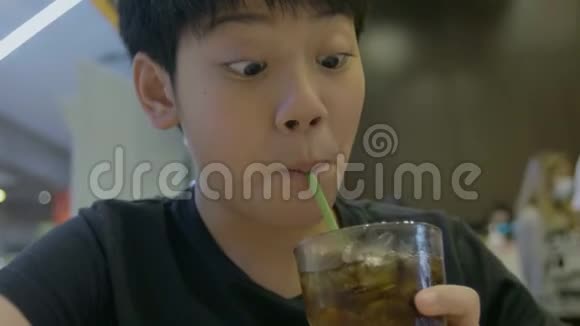 慢动作的少年喝着一杯清爽冰凉的碳酸可乐喝着笑着脸视频的预览图