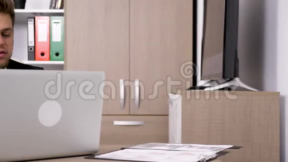 离婚的商人微笑着在办公桌前工作然后从桌子上拿起相框盯着它视频的预览图