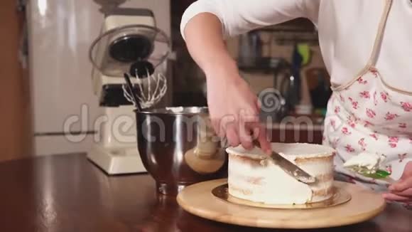 一个女人的手特写镜头她在蛋糕的一侧涂上奶油视频的预览图