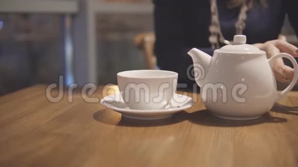 白色茶壶和杯子在城市咖啡馆的桌子上视频的预览图