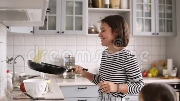 一位棕色短发的美女在煎锅里翻着煎饼微笑着视频的预览图