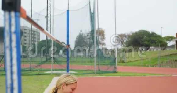 女运动员在体育场地使用手机4k视频的预览图