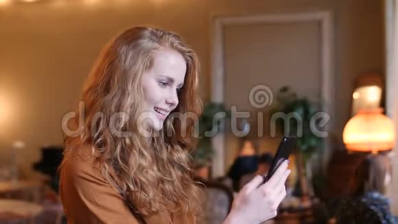 年轻的红发白种人使用智能手机技术在咖啡厅视频的预览图
