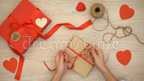 木质背景的人包装工艺情人节礼品盒准备视频的预览图