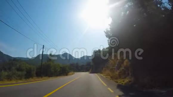 在阳光明媚的夏天汽车在山林道路上转弯视频的预览图