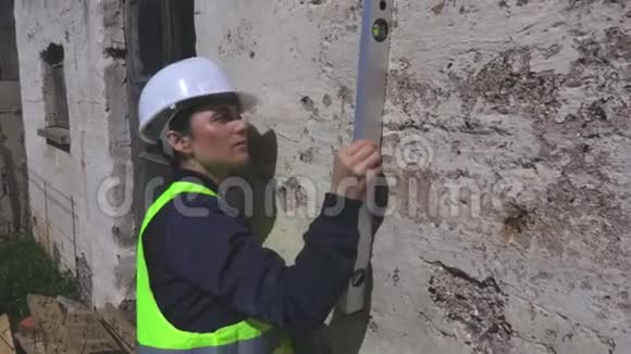 女建筑工人检查墙壁的精神水平视频的预览图