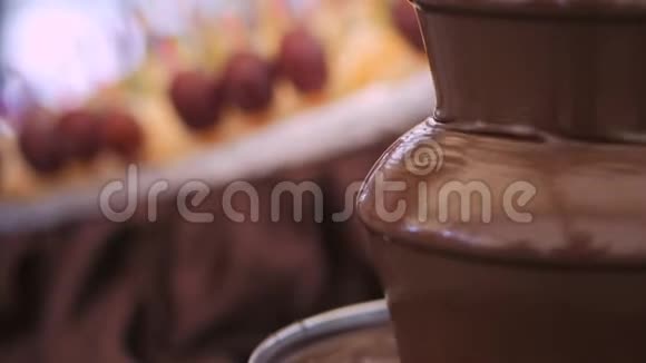 在下雨的巧克力火锅喷泉里品尝水果串视频的预览图