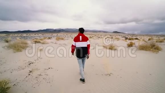 孤独的人走在沙漠之路上视频的预览图