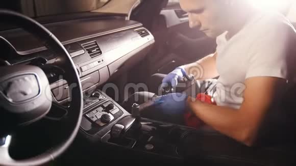 汽车服务一个年轻人用自动刷子清洗汽车面板视频的预览图