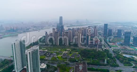乘坐无人机飞越中国大城市瓜州上空飞越江边的高楼大厦视频的预览图