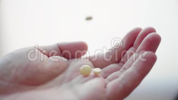 许多医疗药丸药片胶囊和药物正落在成年男子手中视频的预览图
