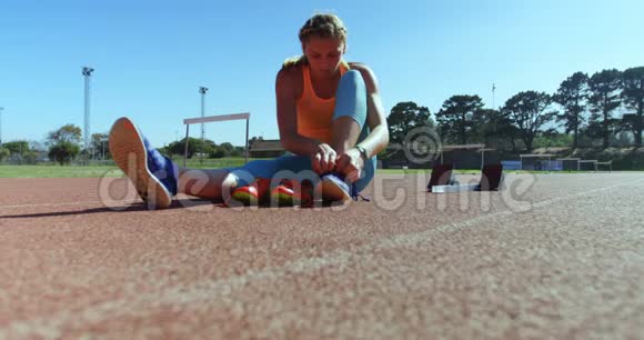 女运动员在运动场系鞋带4k视频的预览图