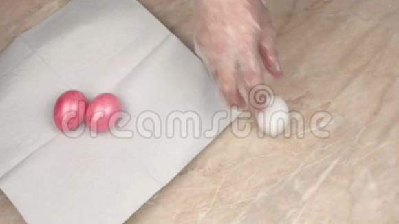 一个人在节日复活节特写准备季节性的节日里用粉红色的珍珠色画鸡蛋视频的预览图