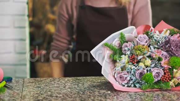 一个女花店选择一条丝带来装饰一束花把手举起来视频的预览图