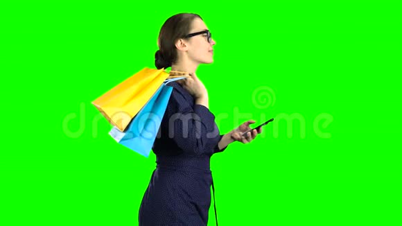 戴眼镜的女孩拨通电话里的信息去商店她从购物中心情很好绿色屏幕视频的预览图
