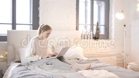 坐在床上工作的少女视频的预览图