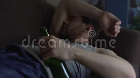 睡在沙发上的废物手里拿着一瓶啤酒嗜酒成瘾视频的预览图