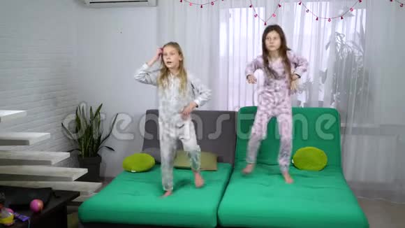 三个穿睡衣的可爱女孩在沙发上跳舞视频的预览图