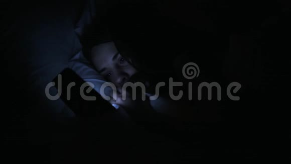晚上床上有智能手机的女人视频的预览图