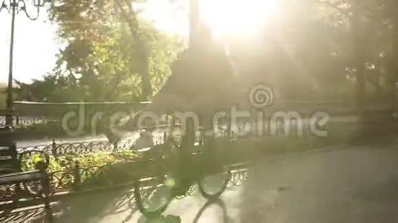 有爱心的年轻夫妇在户外活动中骑在同一辆自行车上玩得很开心背景是阳光背光女孩是视频的预览图