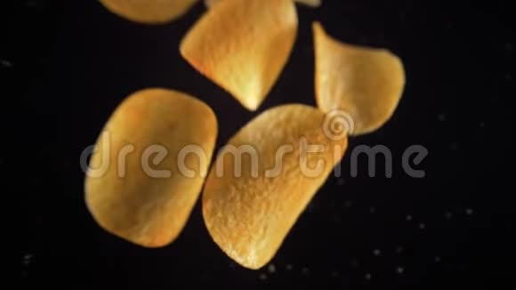 土豆片在黑色背景上飞起来从上面看到的戒指视频的预览图