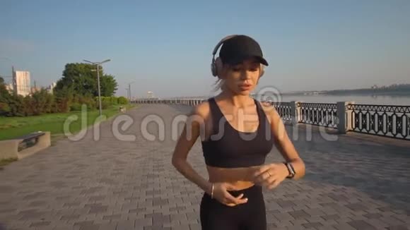 慢镜头拍摄一个女人听音乐跑到河边视频的预览图