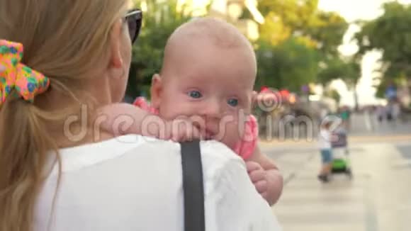 婴儿在母亲怀抱中户外散步视频的预览图