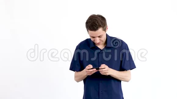 穿蓝色衬衫的男人在智能手机上玩电子游戏视频的预览图