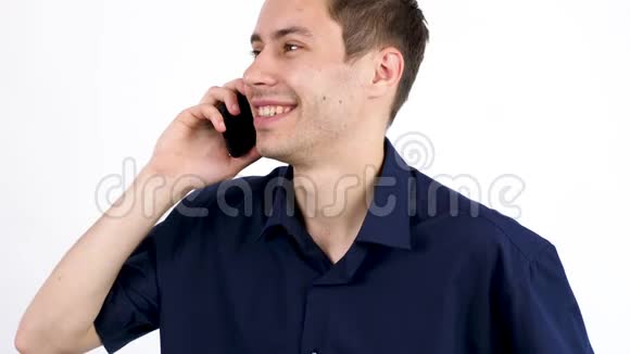 穿蓝色衬衫的年轻人在灰色背景下打电话视频的预览图