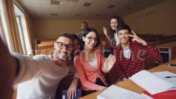 多民族朋友在教室里自拍的视角镜头用手摆姿势视频的预览图