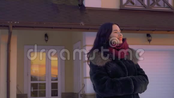 红唇美丽的黑发女子站在她家附近欣赏日落视频的预览图