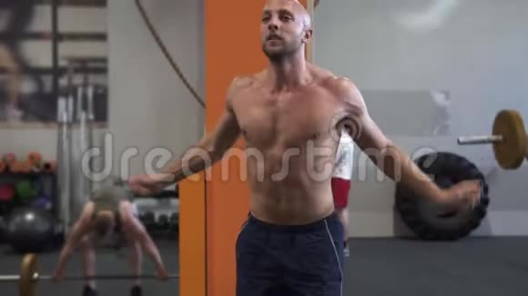 疲惫的健身男子在健身房做双跳绳锻炼视频的预览图