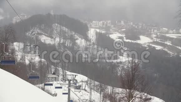 在山上在积雪覆盖的山丘和建筑物上特写索道吊舱库存录像滑雪视频的预览图