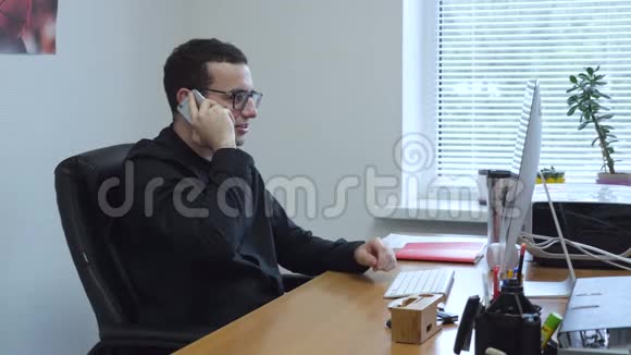 上班的商人在办公室里一桌一桌地用手机说话视频的预览图