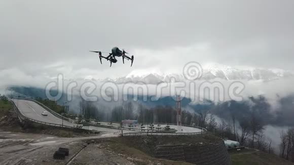 近距离的四架直升机无人机飞行在道路上山在白色的雾和雪的背景股票视频的预览图